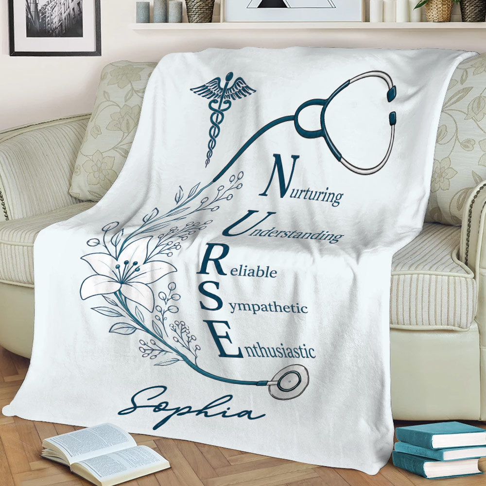 Nursing throw blanket draped over a couch with a stethoscope, caduceus symbol, and floral artwork