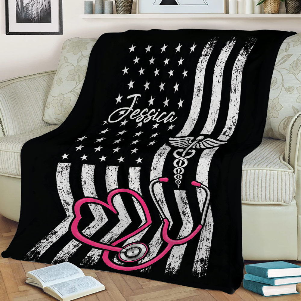 Nurse throw blanket displayed on a couch with stethoscope and patriotic flag-inspired design
