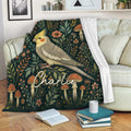 Cockatiel blanket draped over a sofa, showing botanical bird artwork in a cozy living room