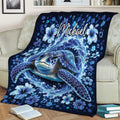 Ocean turtle blanket draped over a couch with swirling waves, bubbles, and blue hibiscus flowers