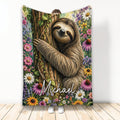Sloth throw blanket featuring a smiling sloth on a tree surrounded by colorful woodland flowers