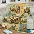 Close lifestyle view of a sloth throw blanket on a sofa featuring colorful panels and sleepy sloth illustrations