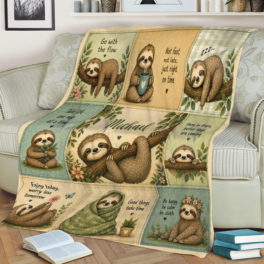 Close lifestyle view of a sloth throw blanket on a sofa featuring colorful panels and sleepy sloth illustrations