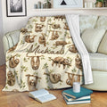 Sloth blanket draped over a sofa, featuring playful sloths and leafy branches in a cozy room
