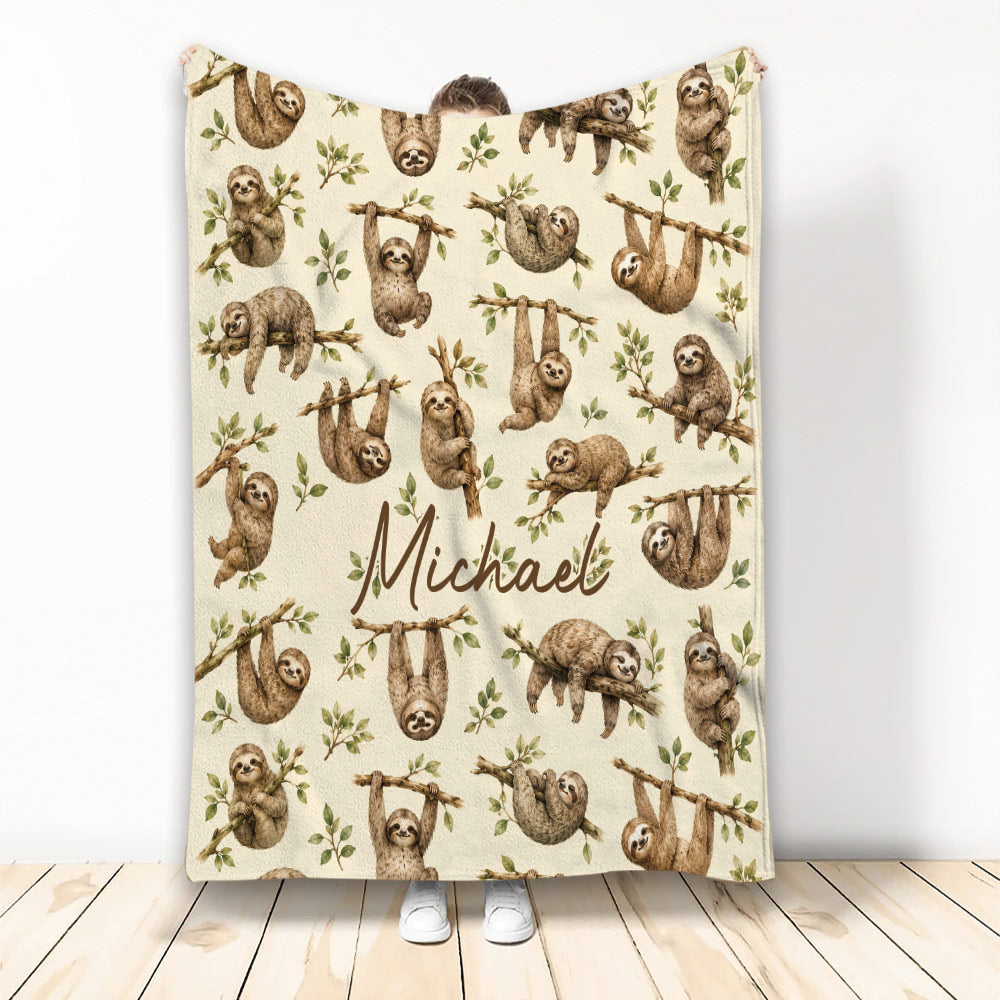 Sloth throw blanket with watercolor-style sloths on leafy branches in a warm neutral design