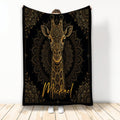 Black and gold giraffe throw blanket with ornate mandala artwork displayed against a light background