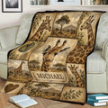 Safari giraffe throw blanket displayed on a couch with repeated giraffe portraits, landscapes, leaves, and animal patterns