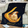 Celestial guinea pig blanket displayed on a couch with a guinea pig nestled in a golden crescent moon