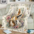 Guinea pig throw blanket draped over a sofa, showing detailed cavy artwork among flowers and greenery