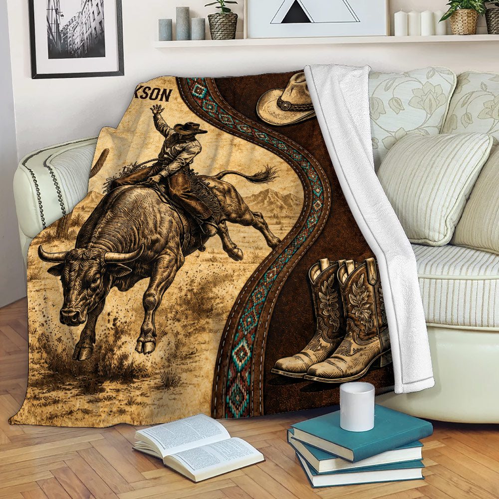 Rodeo bull riding throw blanket displayed on a sofa with cowboy, bull, hat, boots, and western artwork