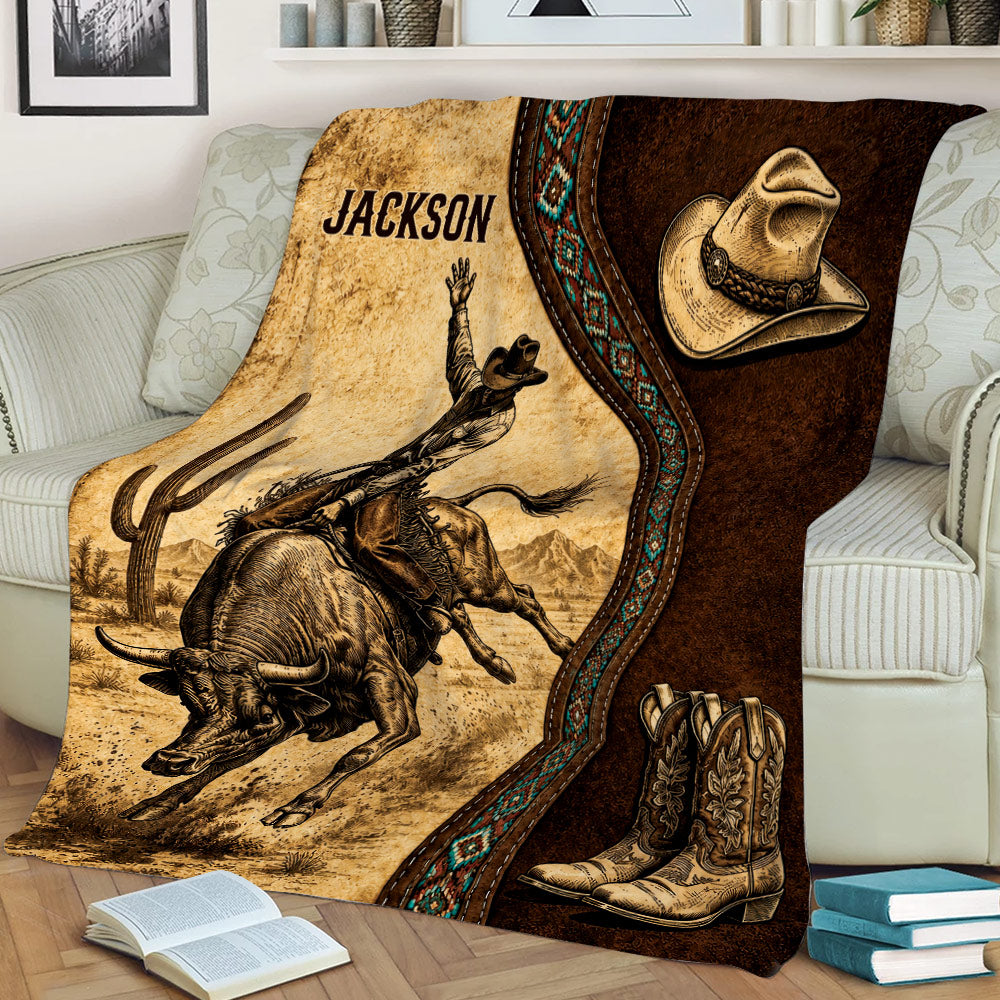 Rustic rodeo throw blanket on a couch featuring bull riding artwork, desert landscape, cowboy hat, and boots