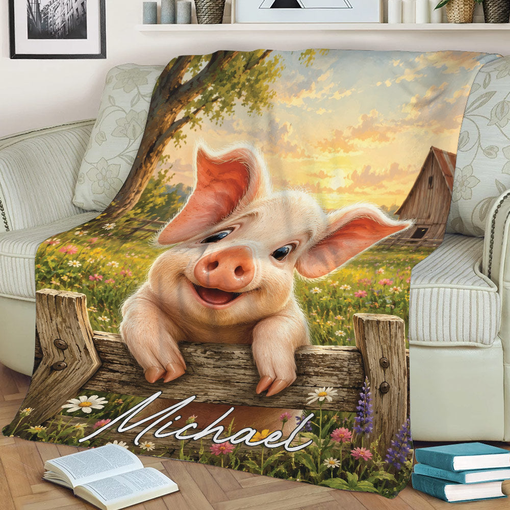 Pig blanket displayed on a sofa with playful piglet artwork, rustic fence, barn, and meadow flowers