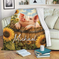 Pig throw blanket draped over a sofa with sunflower farm artwork and a cozy living room setting