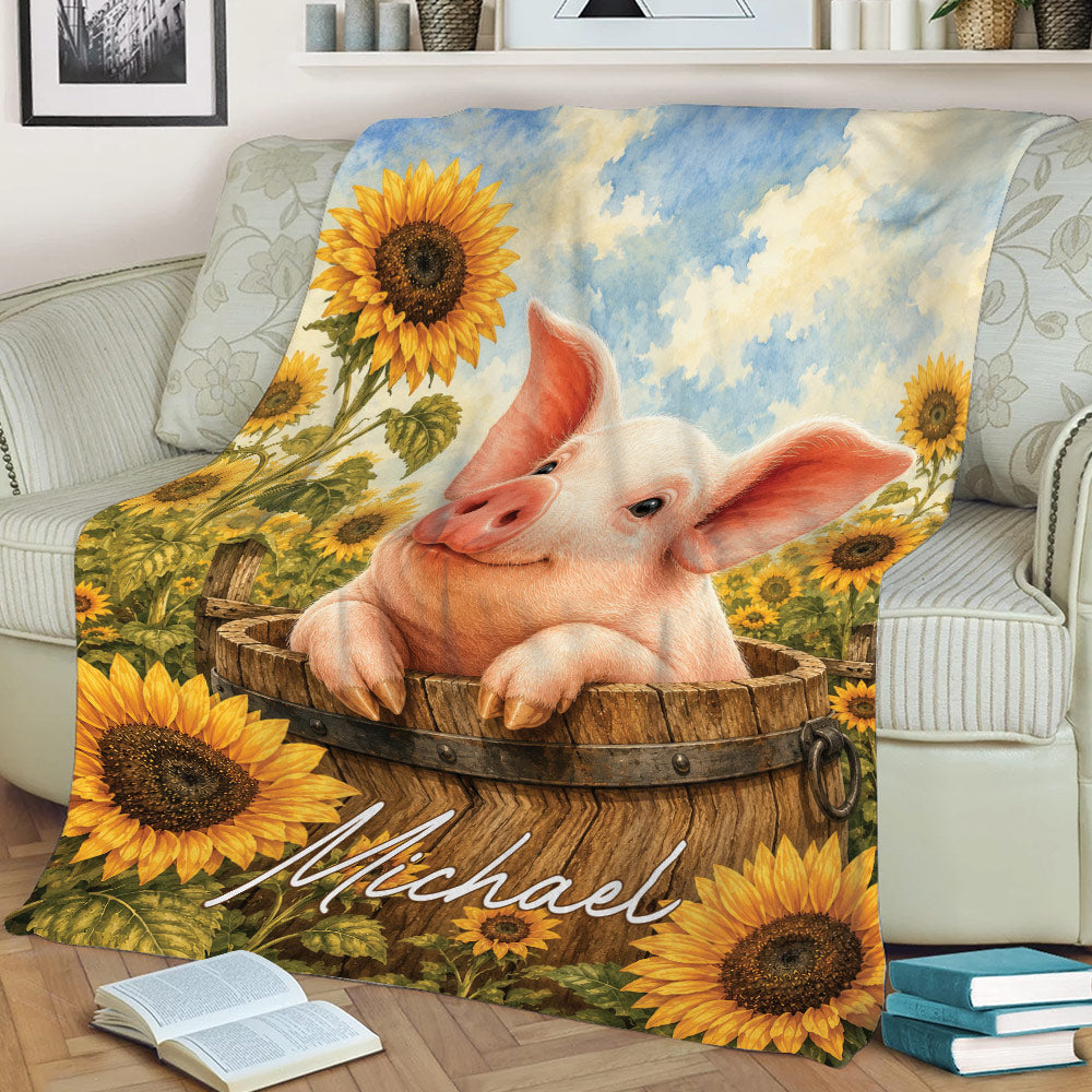 Sunflower pig blanket displayed on a sofa, featuring a cheerful pig in a rustic wooden barrel