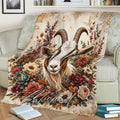 Rustic goat throw blanket displayed on a couch with a horned goat and richly colored flowers