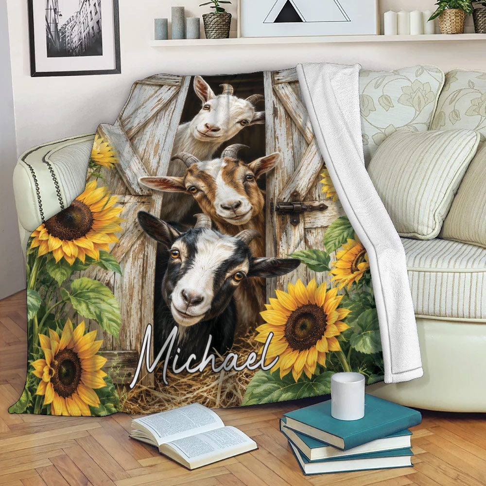 Rustic goat throw blanket draped over a sofa with barn doors, sunflowers, and three goats