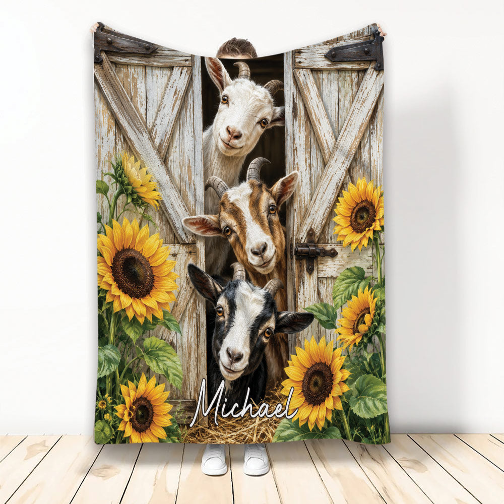 Goat blanket featuring three goats peeking through a rustic barn door surrounded by bright sunflowers