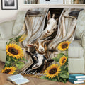 Farmhouse goat blanket displayed on a sofa with playful goats, weathered wood, and sunflower artwork