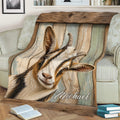 Close view of a rustic goat throw blanket styled across a sofa with detailed farm artwork