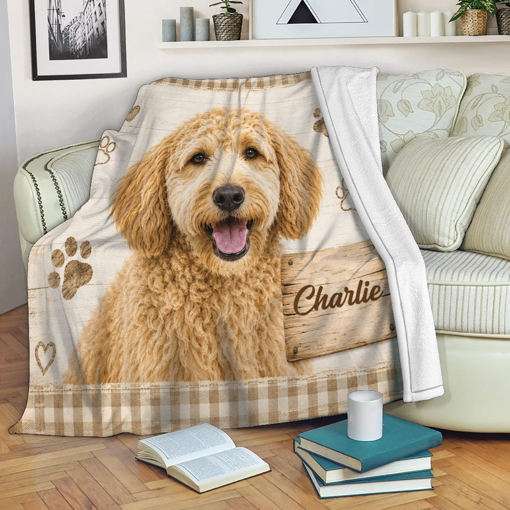Labradoodle blanket displayed on a sofa with rustic wood artwork, paw prints, hearts, and cozy living room decor