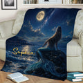 Mermaid throw blanket displayed on a sofa with a moonlit sea, starry sky, rocky shore, and blue tail