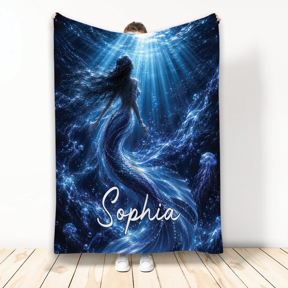Custom mermaid blanket featuring a luminous underwater scene with flowing tail, jellyfish, bubbles, and blue ocean light
