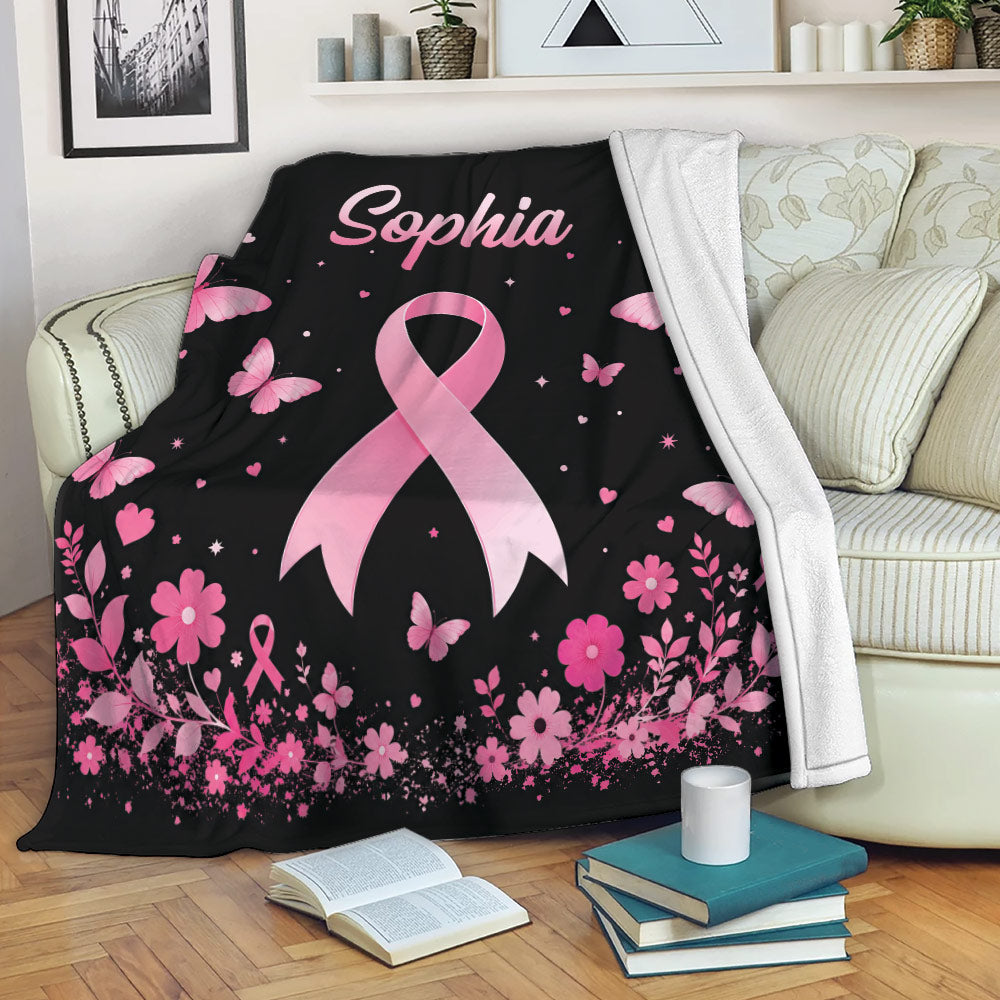 Pink ribbon breast cancer awareness throw blanket styled across a living room sofa