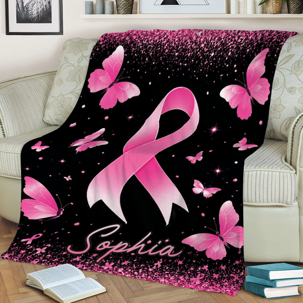 Pink ribbon breast cancer awareness blanket draped over a couch with butterfly artwork