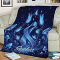 Blue diabetes awareness blanket draped over a couch with butterflies, mushrooms, stars, and ribbon artwork