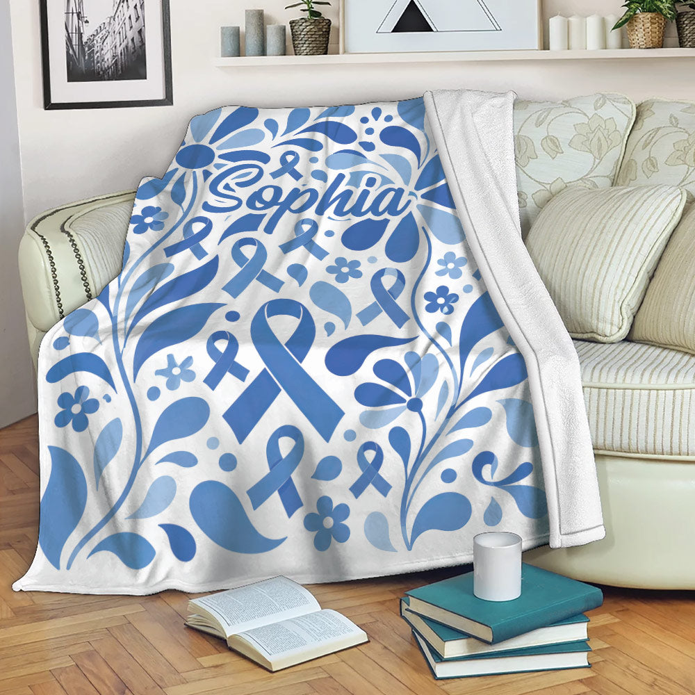 Blue diabetes awareness throw blanket with floral ribbons draped across a living room sofa