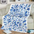 Blue ribbon diabetes awareness blanket displayed over a sofa with decorative floral artwork