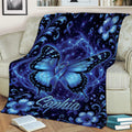 Blue butterfly awareness blanket draped over a couch with floral details and ribbon motifs