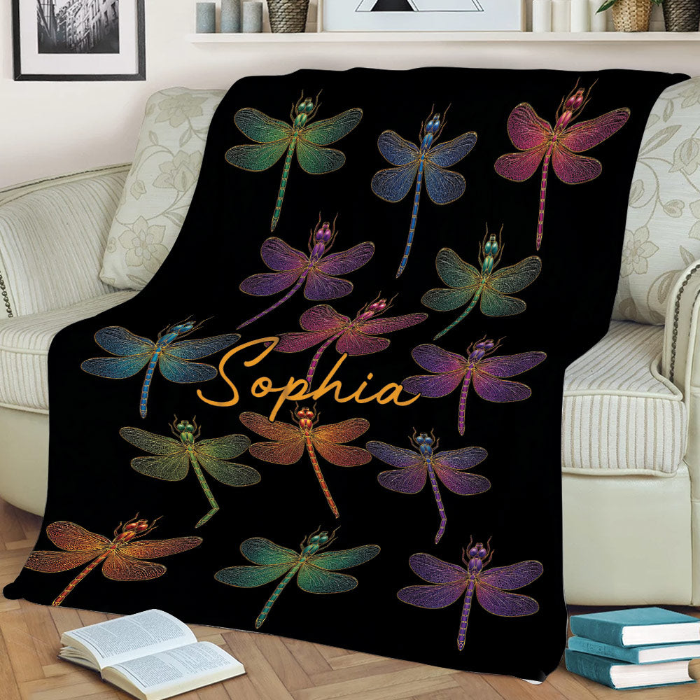 Dragonfly throw blanket draped over a couch with vibrant multicolor insect artwork