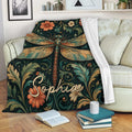Dragonfly throw blanket draped over a sofa with rich floral and botanical artwork