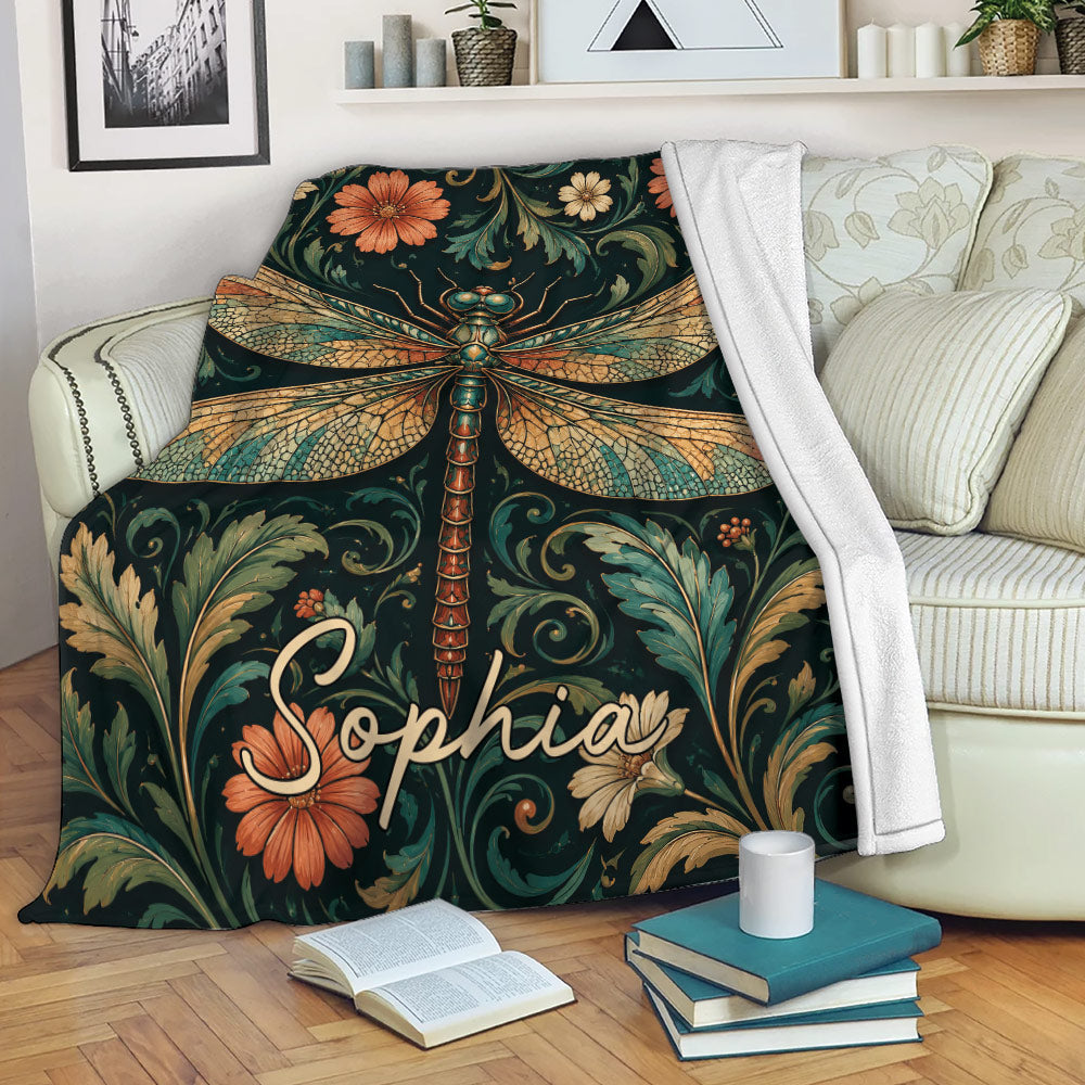 Dragonfly throw blanket draped over a sofa with rich floral and botanical artwork
