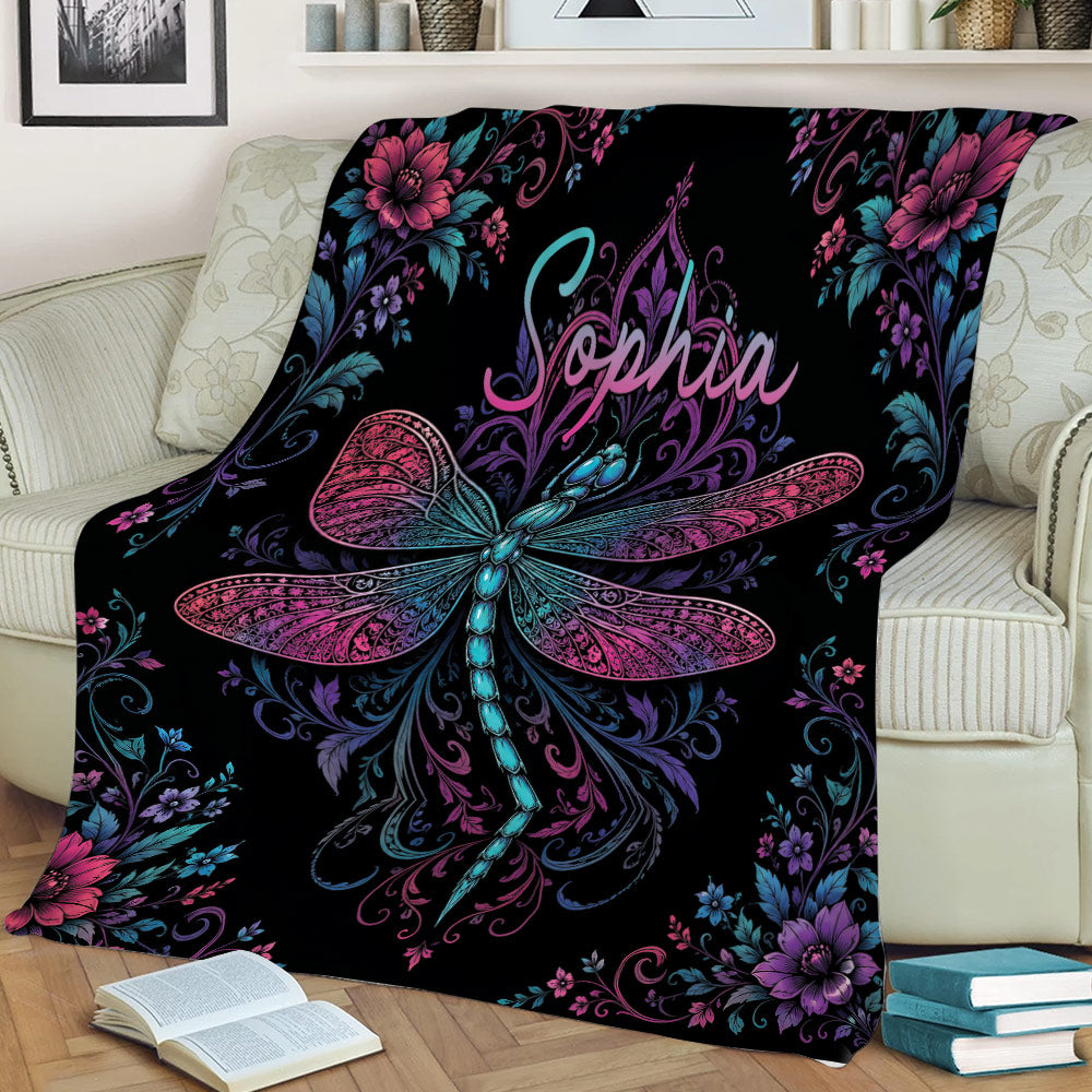 Ornate dragonfly throw blanket displayed on a sofa with colorful botanical and floral details