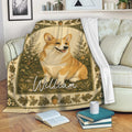 Corgi blanket draped over a sofa, featuring warm woodland colors, flowers, leaves, and acorns