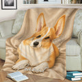 Corgi throw blanket displayed on a sofa with a relaxed watercolor dog portrait