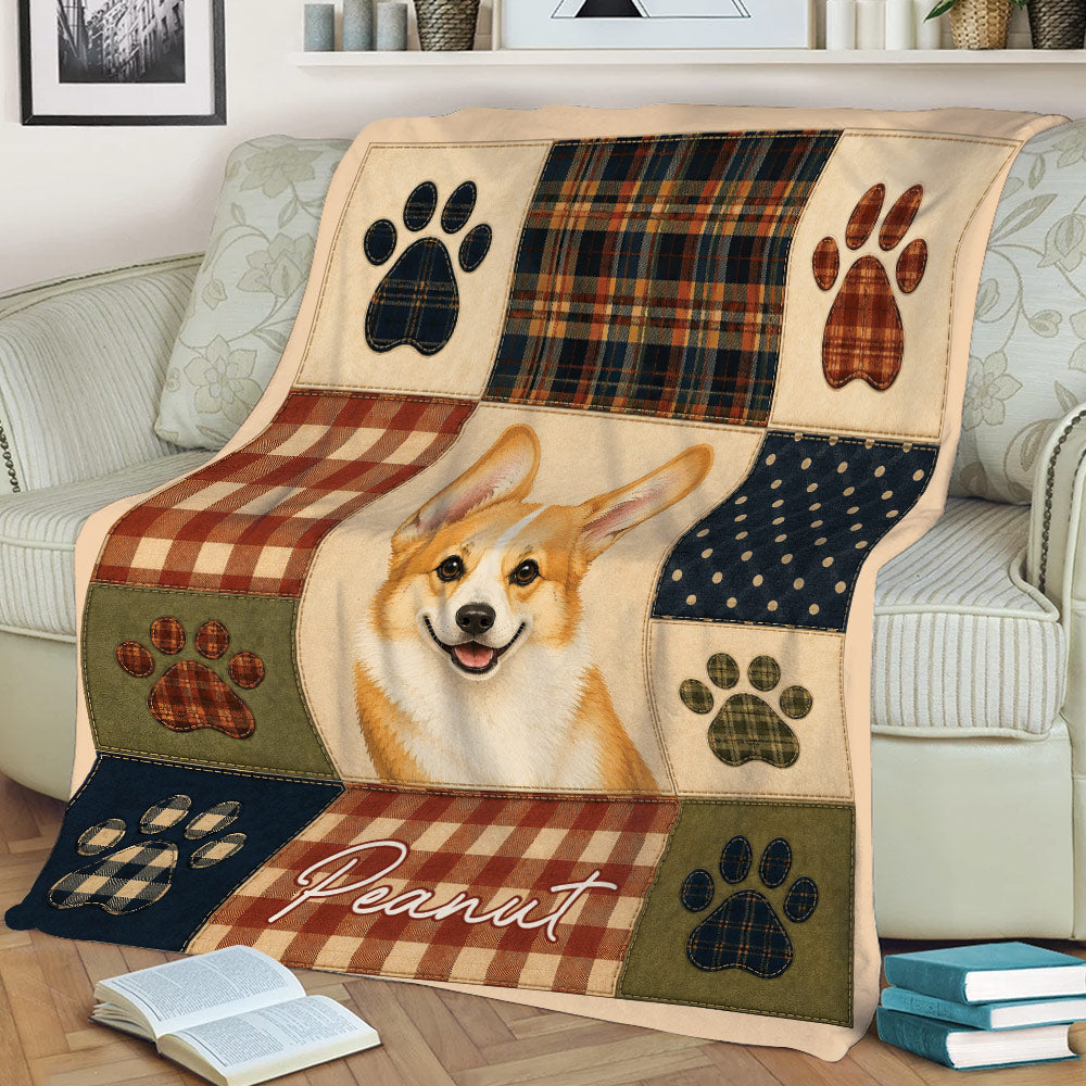 Corgi throw blanket styled on a couch with patchwork plaid sections and colorful paw-print motifs