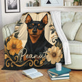 Miniature Pinscher throw blanket displayed on a sofa with floral dog artwork