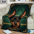 Close view of a black and tan Miniature Pinscher blanket styled across a sofa with ornate gold accents