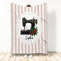 Sewing throw blanket featuring a black vintage-style machine, holly berries, and striped artwork