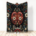 Ornate ladybug blanket with red floral wings and botanical artwork displayed against a light background