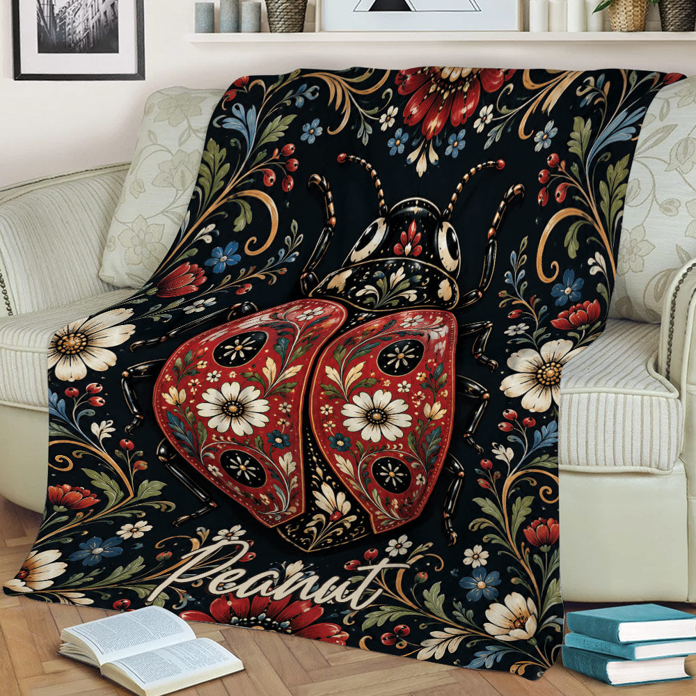 Decorative ladybug blanket featuring red patterned wings, flowers, and dark botanical artwork on a sofa