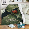 Ladybug blanket draped over a sofa with leafy botanical artwork and a red spotted insect