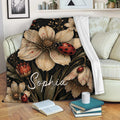 Ladybug floral throw blanket displayed on a sofa with cream flowers, red insects, and botanical artwork