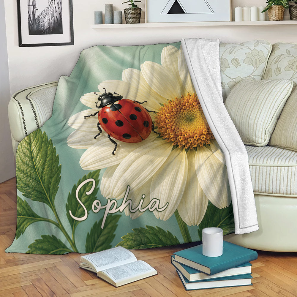 Ladybug blanket draped over a sofa with a red spotted beetle and daisy garden artwork