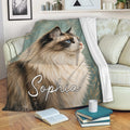 Ragdoll cat blanket draped over a sofa, featuring blue-eyed cat artwork in a cozy living room