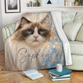 Ragdoll cat blanket draped over a sofa, showing blue-eyed cat artwork in a cozy room