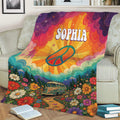 Colorful hippie blanket displayed on a sofa with peace symbol, vintage van and psychedelic floral artwork